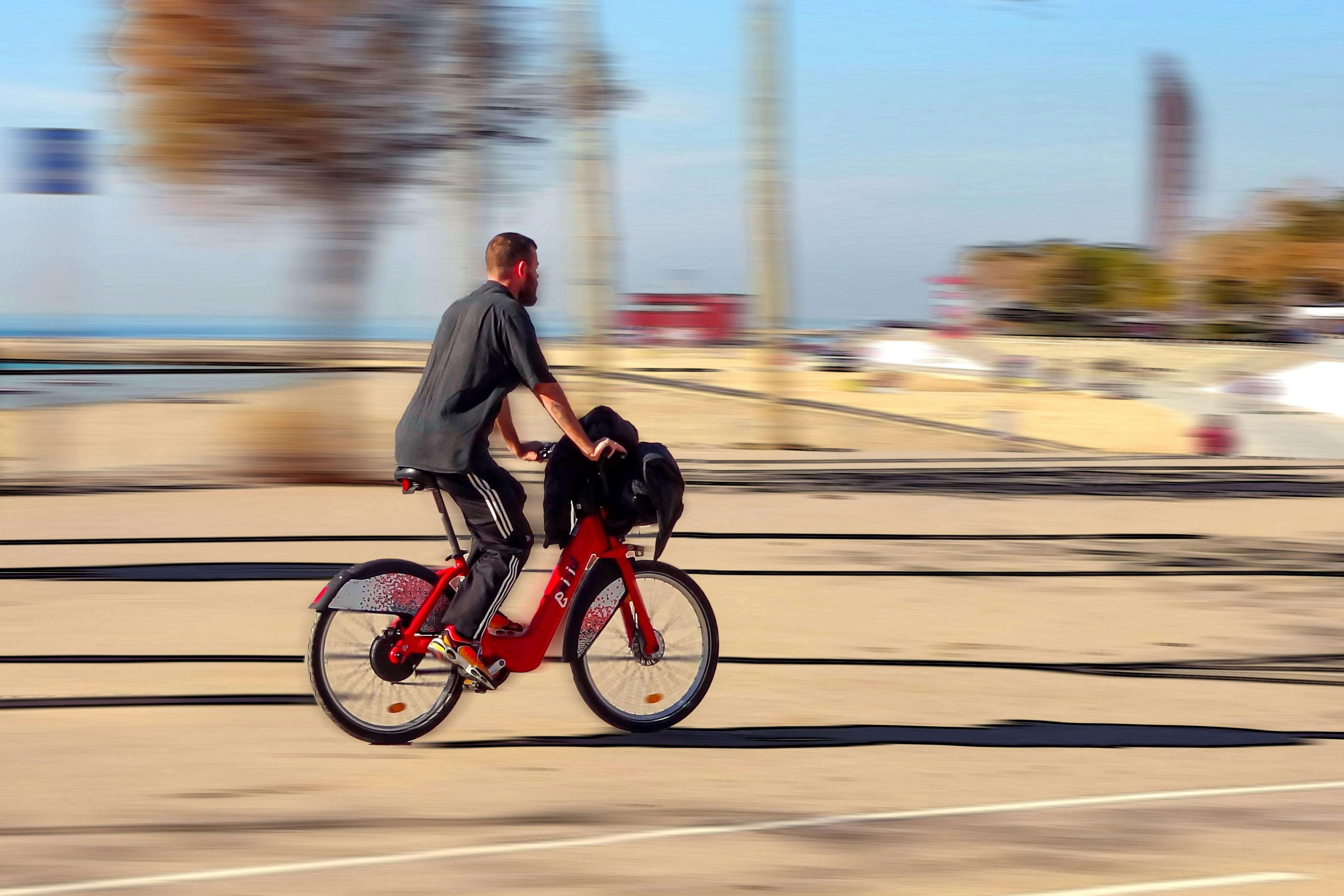 man in black jacket riding red motorcycle on road during daytime